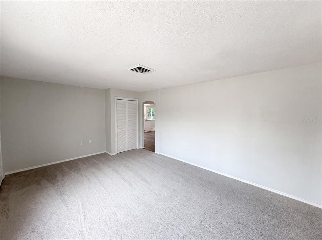 An empty room with gray carpet, light gray walls, and a white louvered closet door — 8053 EMBASSY BOULEVARD, PORT RICHEY, FL