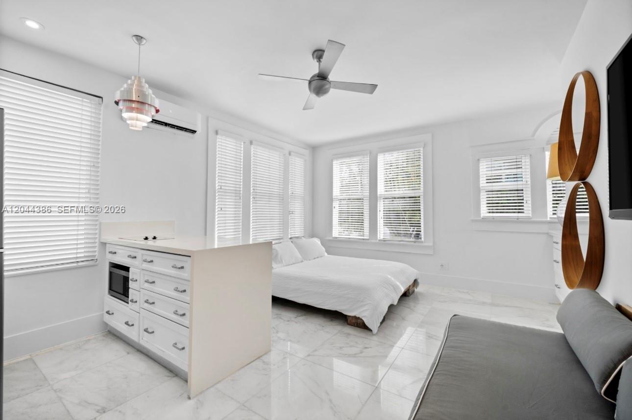 A studio apartment features a kitchenette, a bed, a ceiling fan, and white tile flooring — 739 2nd St # 6, Miami Beach FL 33139, MIAMI BEACH, FL
