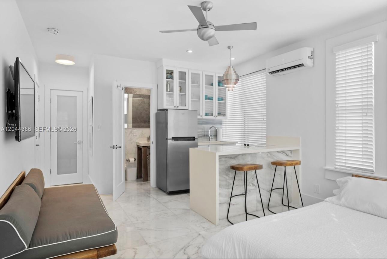 This studio apartment features a kitchenette with marble counters, a sofa, and a bed — 739 2nd St # 6, Miami Beach FL 33139, MIAMI BEACH, FL