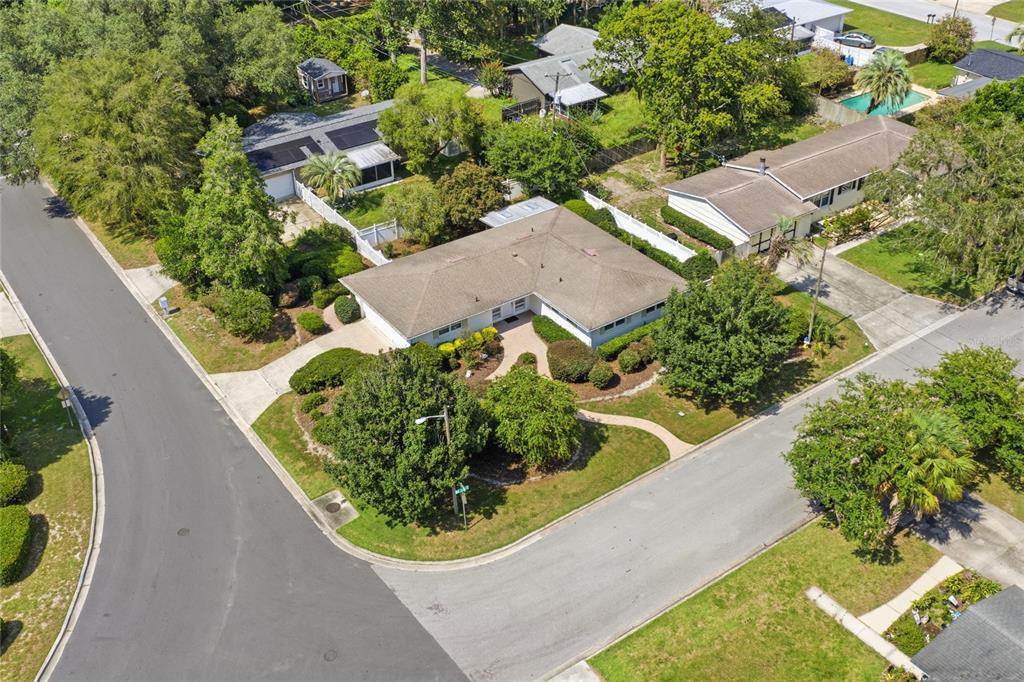 An aerial view shows a single-story house with a tan roof on a corner lot — 2138 NW 30TH PLACE, GAINESVILLE, FL
