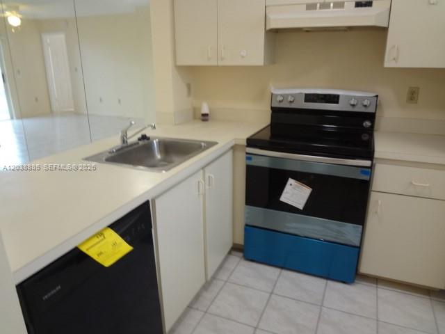 A kitchen features white cabinets, a stainless steel stove, and a black dishwasher — 426 NE 210th Cir Ter # 2, Miami FL 33179, MIAMI, FL
