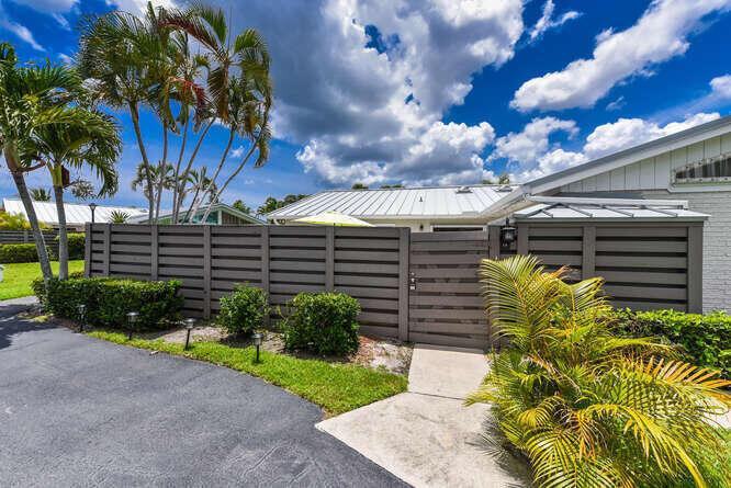A gray horizontal-slat privacy fence encloses a patio area in front of a house — 1801 S Us Highway 1 # 1a, Jupiter FL 33477, JUPITER, FL