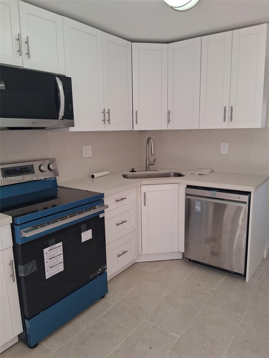 A kitchen features white cabinets, stainless steel appliances, and light-colored countertops — 10029 SW 77th Ct # 0, Miami FL 33156, MIAMI, FL