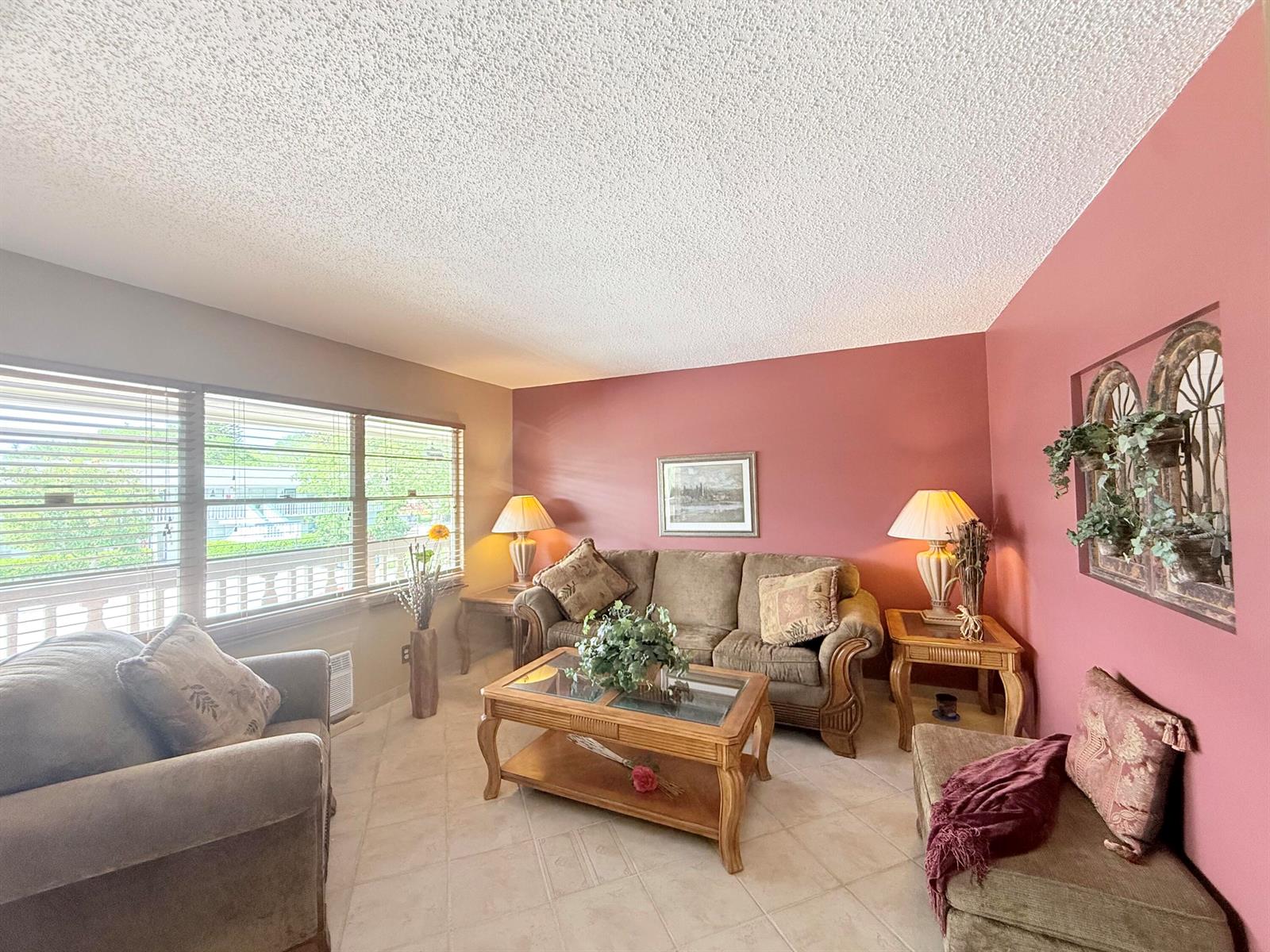 A living room features a brown sofa, matching armchairs, a coffee table, and red walls — 165 Tilford H # 165, Deerfield Beach FL 33442, DEERFIELD BEACH, FL