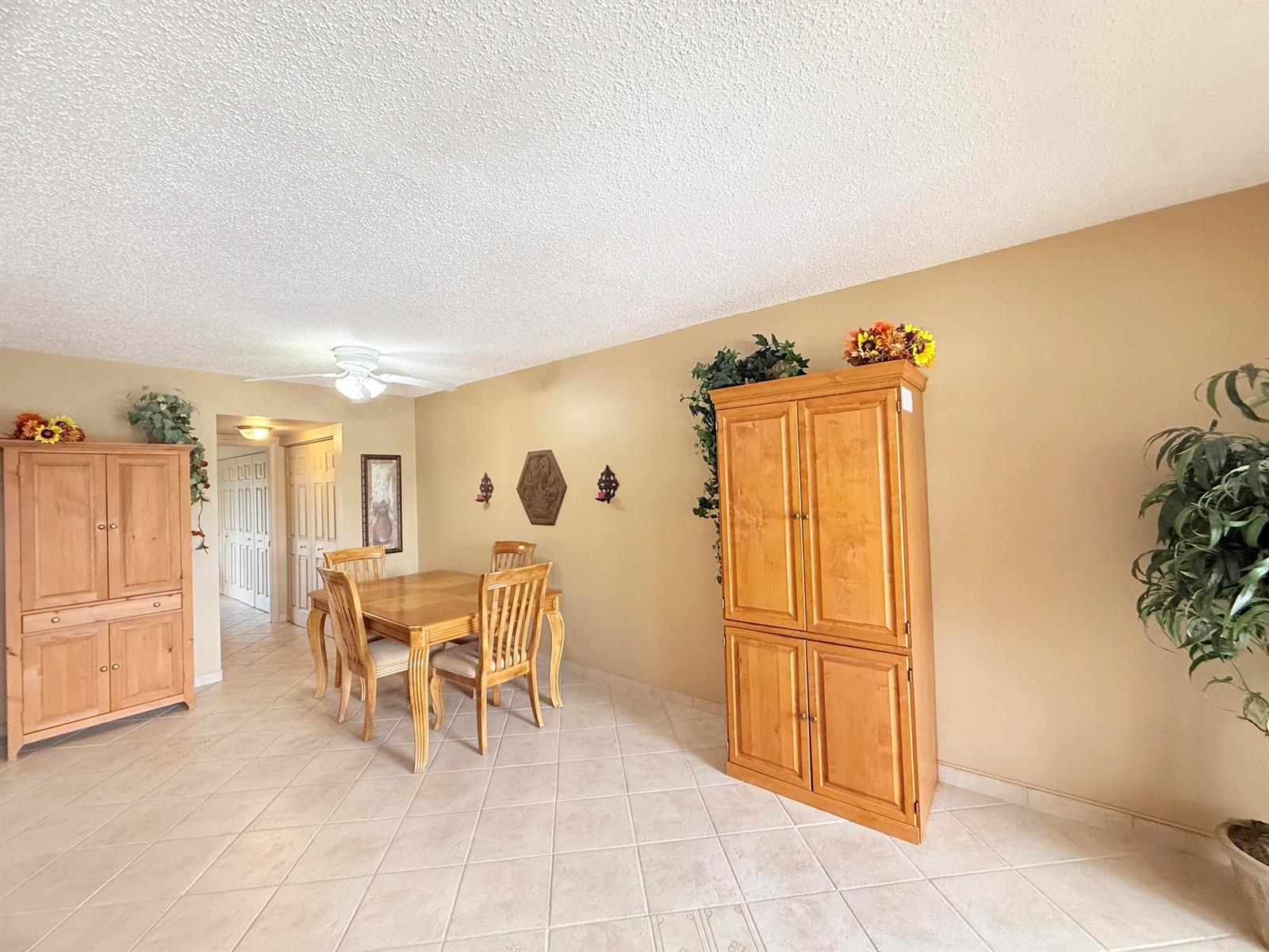 A dining area features tile floors, two wooden cabinets, and a table with four chairs — 165 Tilford H # 165, Deerfield Beach FL 33442, DEERFIELD BEACH, FL