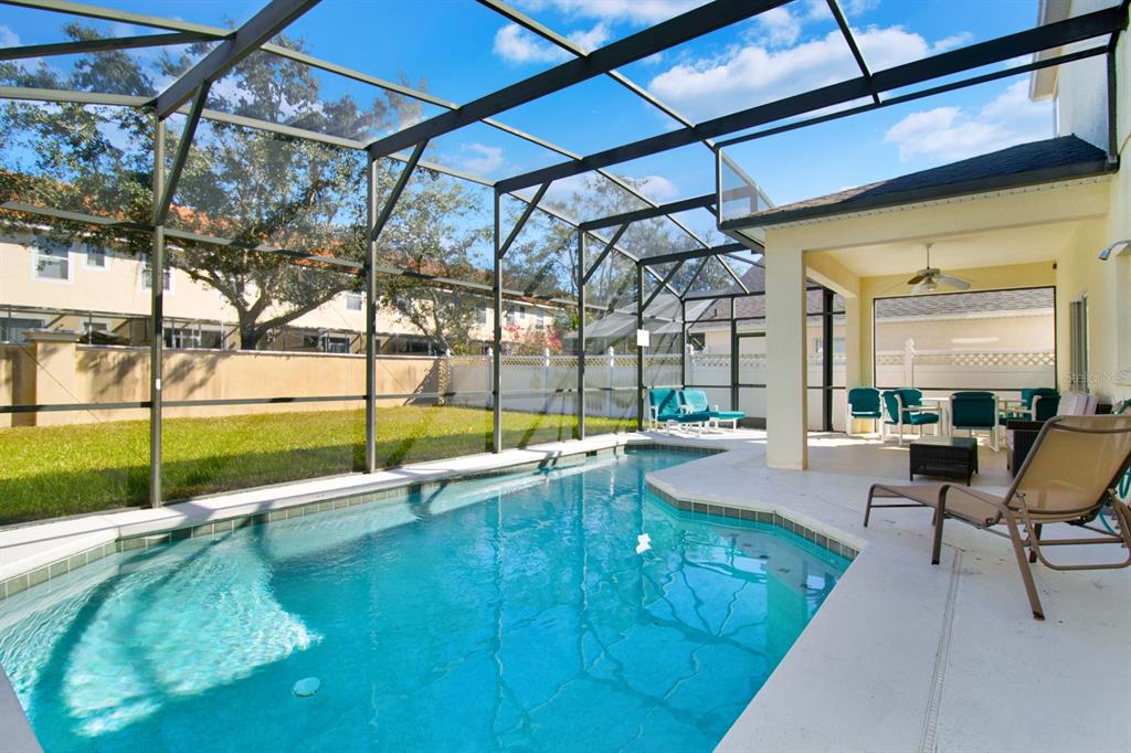 A screened-in swimming pool and patio area with outdoor furniture and a covered lanai — 4603 CUMBRIAN LAKES DRIVE, KISSIMMEE, FL