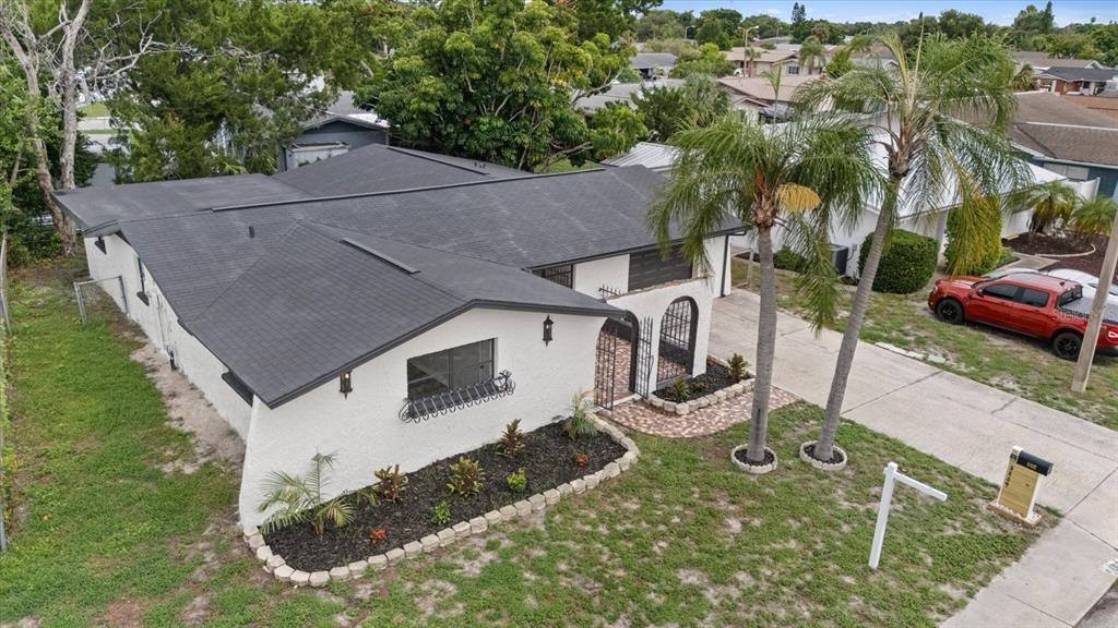 An aerial view of a white stucco house with a dark roof and palm trees — 9401 GLEN MOOR LANE, PORT RICHEY, FL