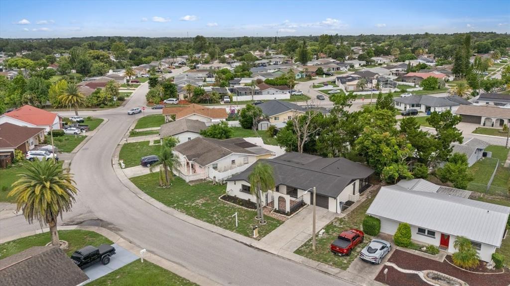 An aerial view of a suburban neighborhood featuring single-story houses, paved streets, and palm trees — 9401 GLEN MOOR LANE, PORT RICHEY, FL