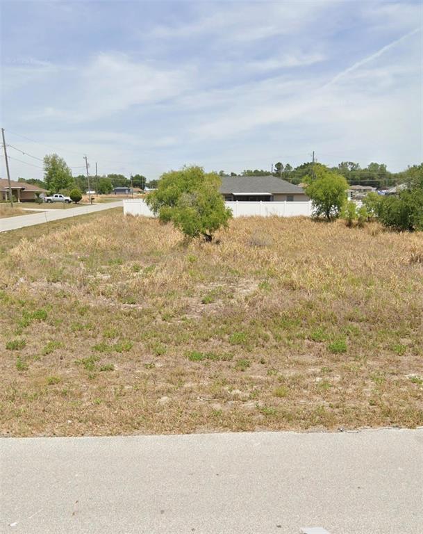 A vacant, grassy residential lot sits next to a paved road and a white fence — TBD DOGWOOD DR CIRCLE, OCALA, FL