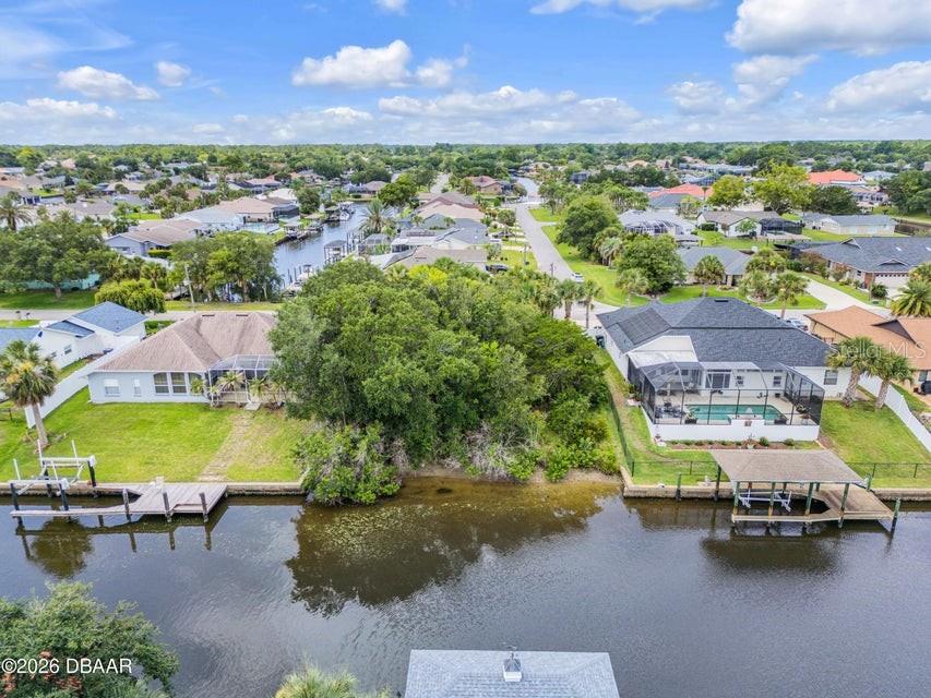 An aerial view shows two waterfront houses with docks separated by a large wooded lot — 9 N CHRISTOPHER COURT, PALM COAST, FL