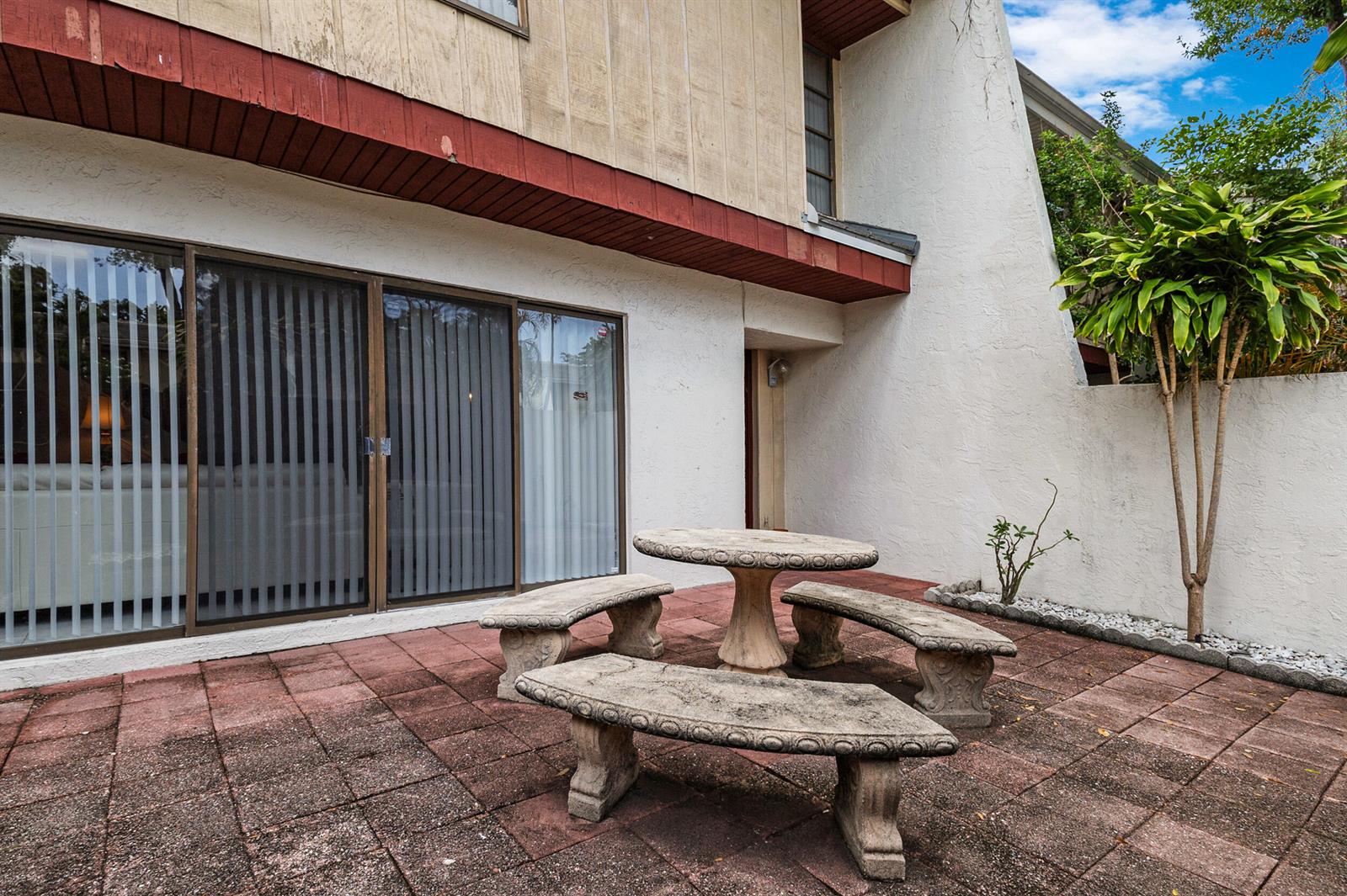 A stone table and three curved benches sit on a red brick patio outside — 3015 Oaktree Lane Unit 277, Hollywood FL 33021, HOLLYWOOD, FL