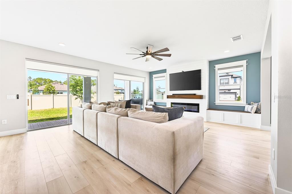 A living room features a large sectional sofa, a fireplace, and a blue accent wall — 2234 MAROON FLAME COURT, OVIEDO, FL