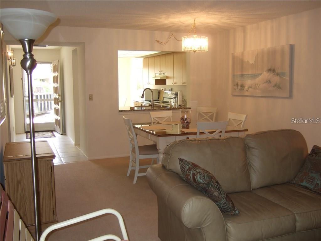 A living room and dining area with a pass-through window to the kitchen — 4397 LONGMEADOW UNIT 35, SARASOTA, FL