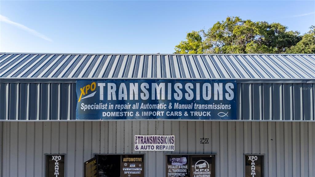 The exterior of an auto repair shop features a metal roof and signage for transmissions — 960 E CARROLL STREET, KISSIMMEE, FL