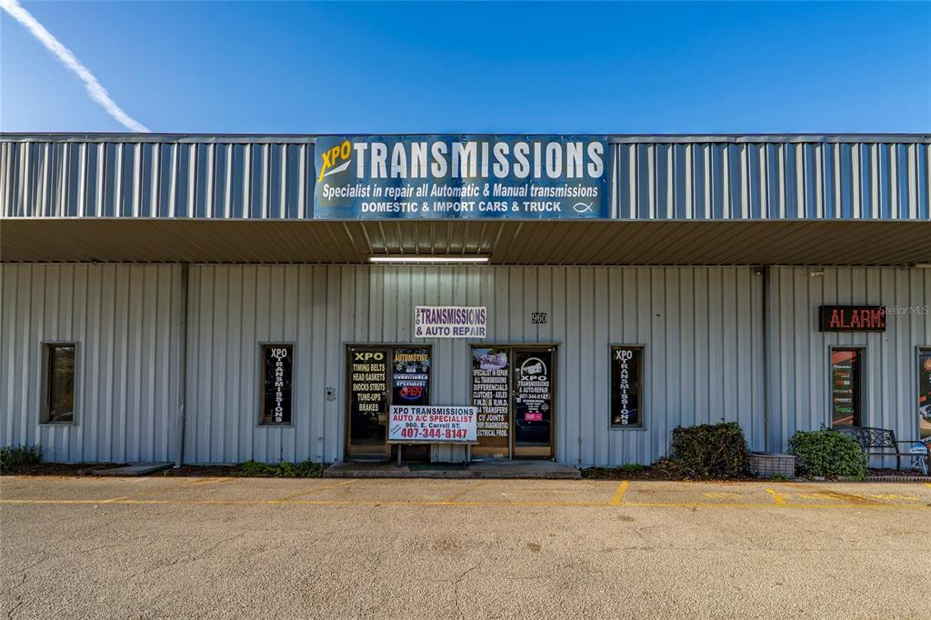 The exterior of a commercial building features a large sign for XPO Transmissions — 960 E CARROLL STREET, KISSIMMEE, FL