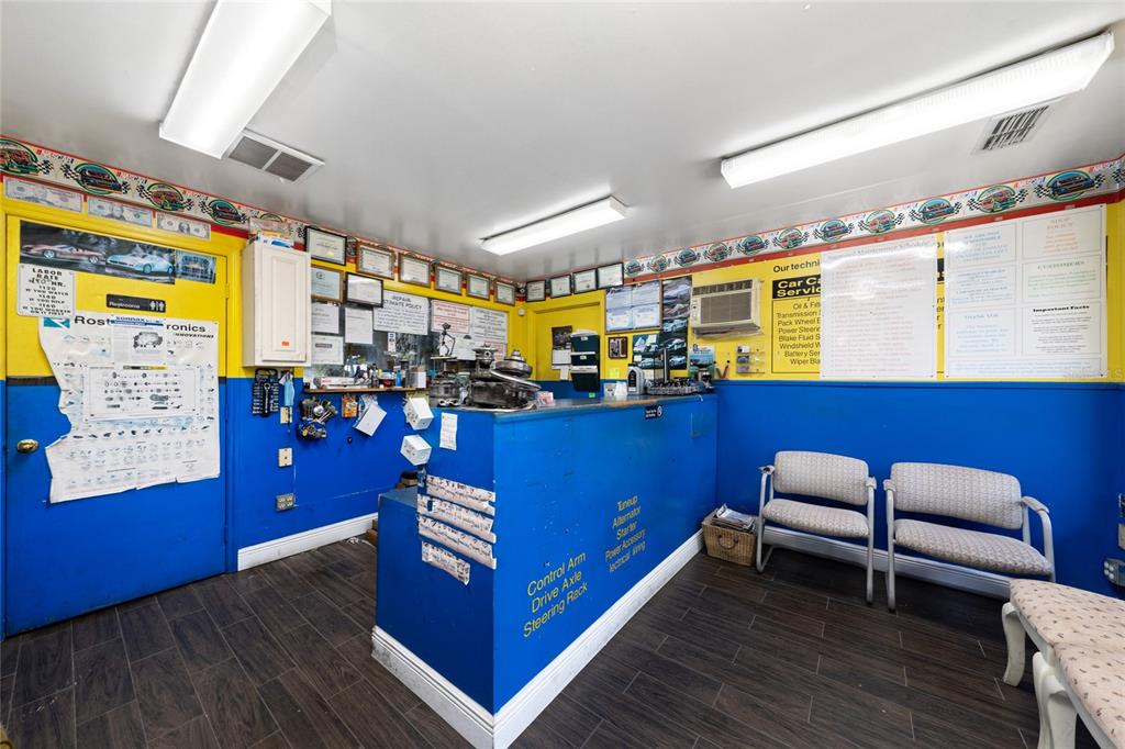 A brightly lit auto repair shop reception area features blue and yellow walls and chairs — 960 E CARROLL STREET, KISSIMMEE, FL