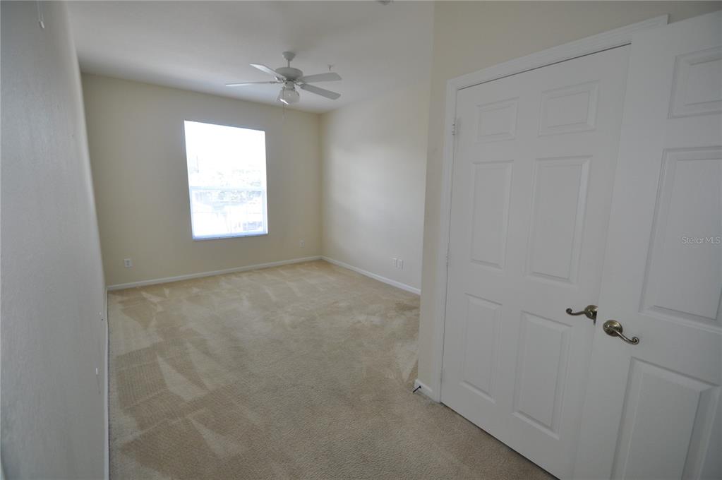 An empty bedroom features beige carpet, light-colored walls, a ceiling fan, and a white closet — 588 BRANTLEY TERRACE WAY UNIT 305, ALTAMONTE SPRINGS, FL