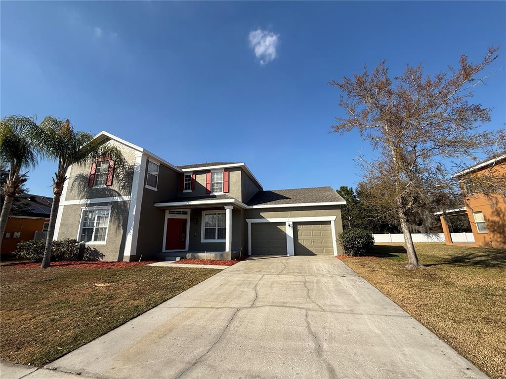 A two-story house with a gray stucco exterior, red shutters, and a two-car garage — 3081 MARSHFIELD PRESERVE WAY, KISSIMMEE, FL