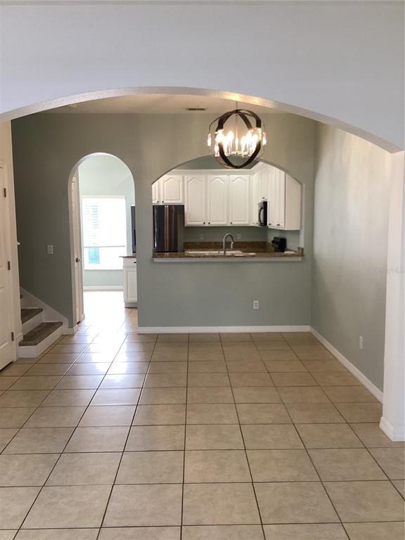 A tiled dining area leads to a kitchen with white cabinets and a breakfast bar — 11932 DEER PATH WAY, ORLANDO, FL