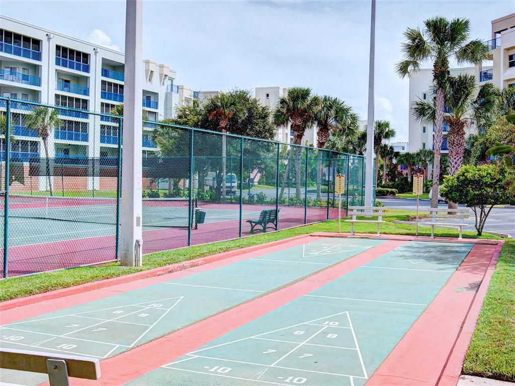 A shuffleboard court sits in front of a fenced tennis court and apartment buildings — 5300 S ATLANTIC AVENUE UNIT 4-503, NEW SMYRNA BEACH, FL