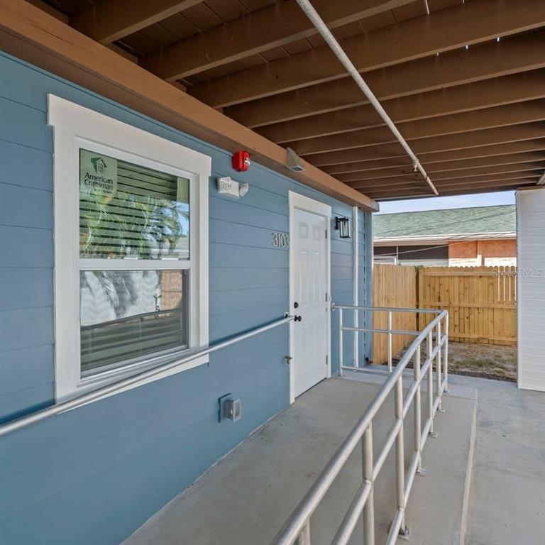 A blue exterior wall features a white door, a window, and a metal handrail — 3103 16TH STREET N UNIT 3103, ST PETERSBURG, FL