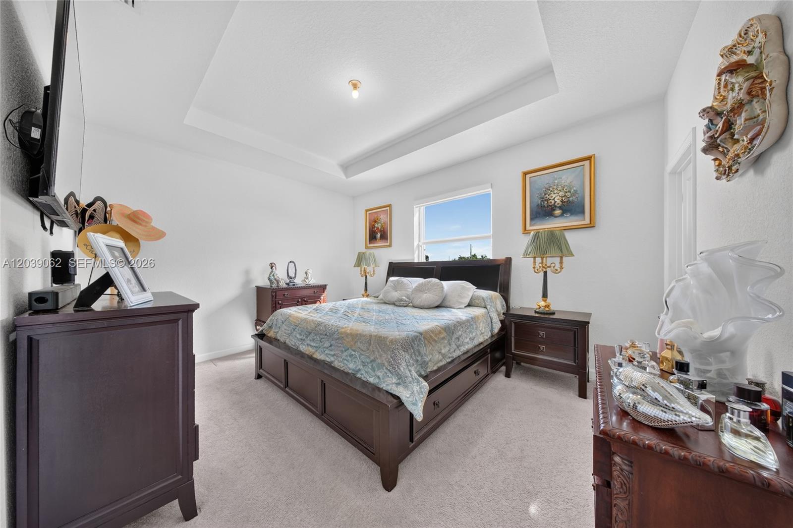 A bedroom features a dark wood bed frame, matching nightstands, and a tray ceiling — 29253 SW 162nd Ct, Homestead FL 33033, HOMESTEAD, FL