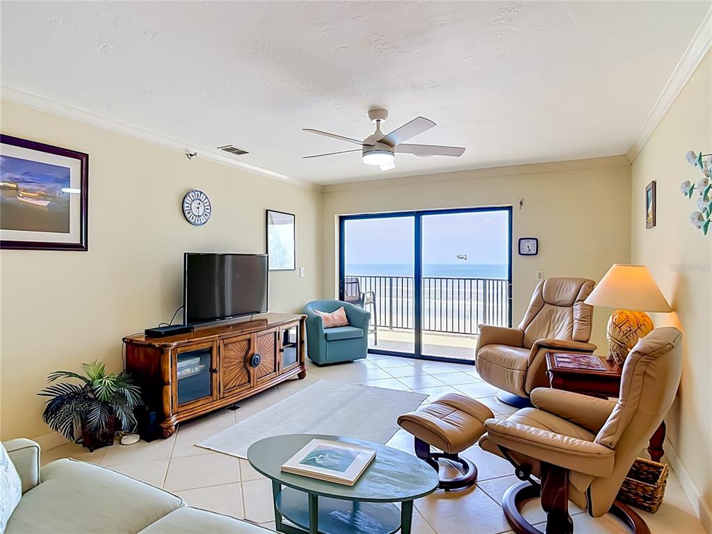 A living room features a television, two leather recliners, and a balcony overlooking the ocean — 3001 S ATLANTIC AVE UNIT 442, NEW SMYRNA BEACH, FL