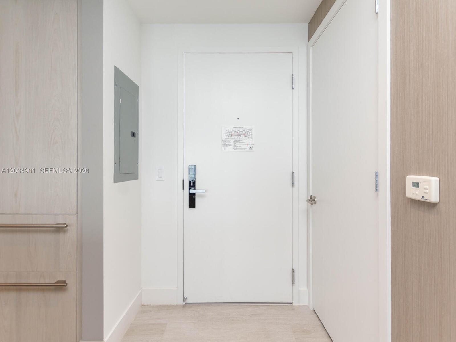 A white entry door with a digital lock stands between a cabinet and a closet — 4010 S Ocean Dr # T3705, Hollywood FL 33019, HOLLYWOOD, FL