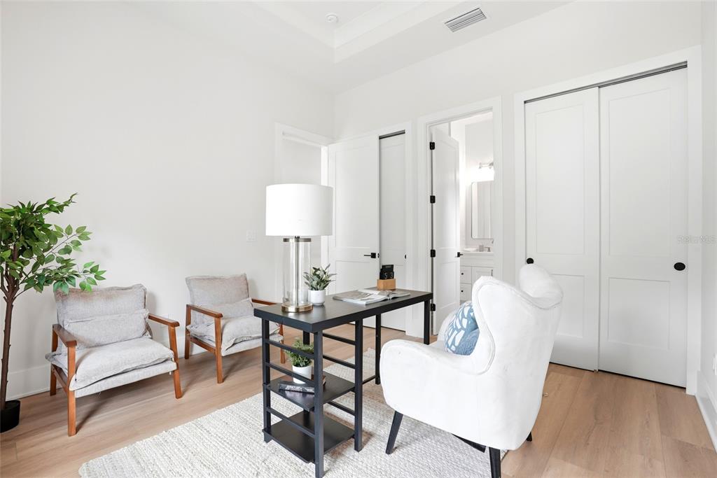 A modern kitchen features white cabinetry, a wood-toned island and range hood, and pendant lighting — 2376 RAJEL AVENUE, SAFETY HARBOR, FL