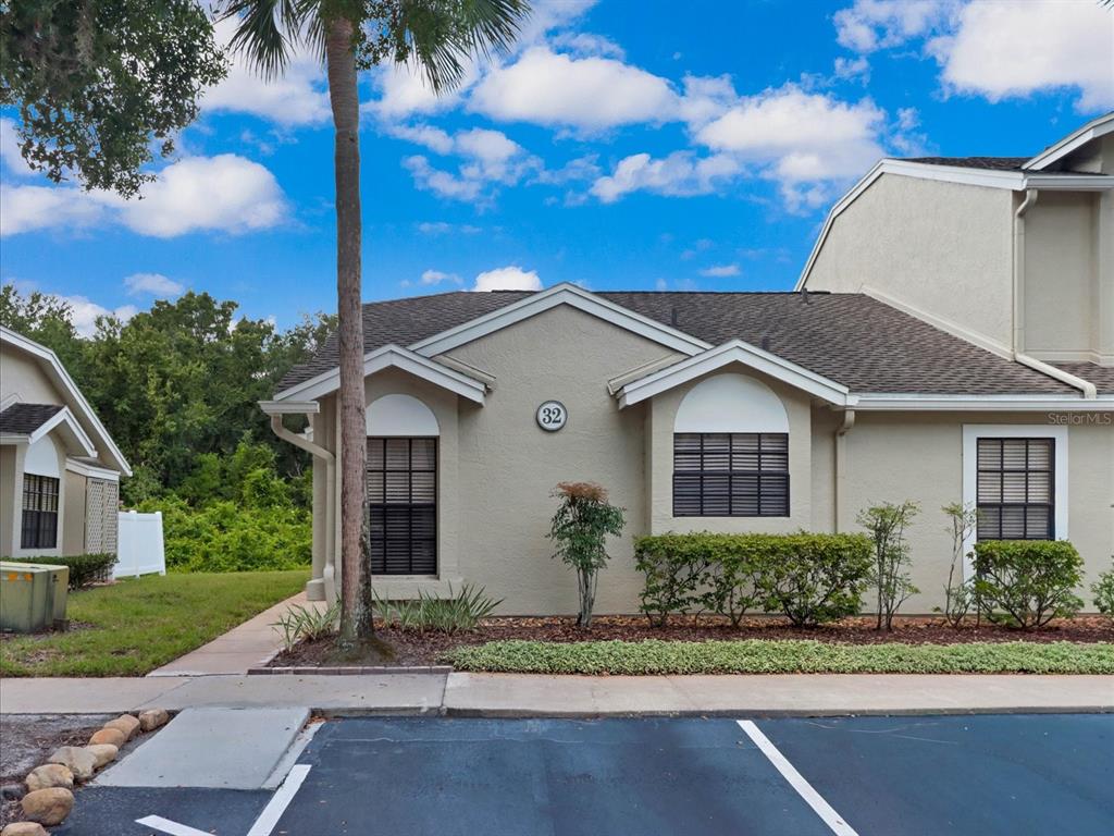 A tan, single-story residential building with a number 32 plaque and a palm tree — 5100 BURCHETTE ROAD UNIT 3200, TAMPA, FL