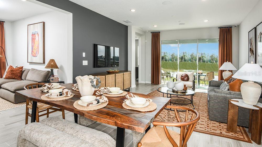 A dining area with a live-edge wood table sits between a living room and patio — 32488 SEA LOCH LOOP, MOUNT DORA, FL