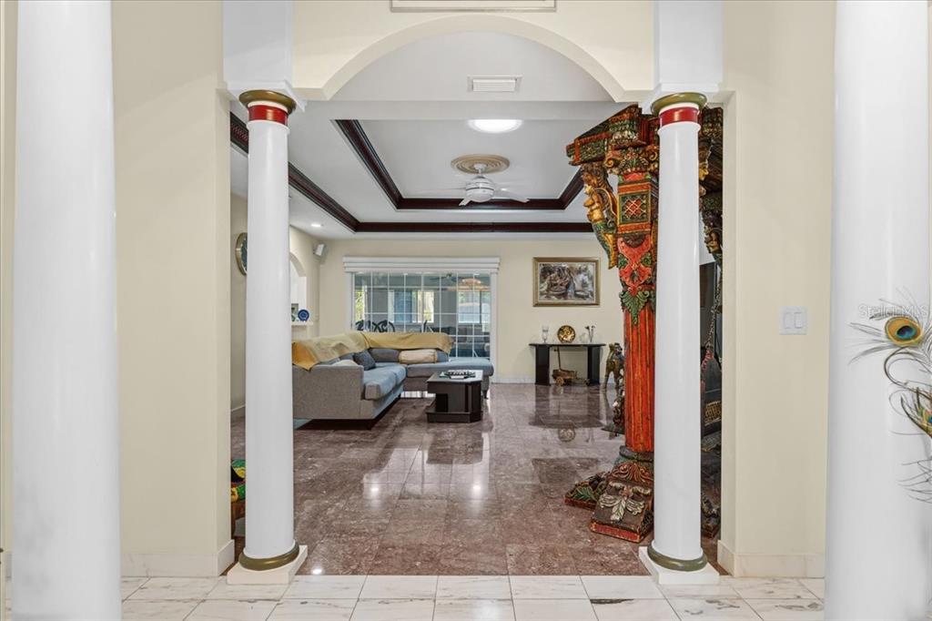 A living room with marble floors is viewed through a wide archway flanked by columns — 196 NW CLUBVIEW CIRCLE, LAKE CITY, FL