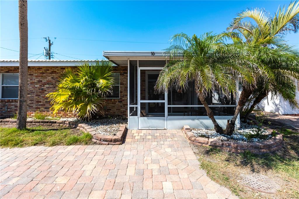 A brick house features a screened-in front porch, a paver walkway, and two palm trees — 6020 MIDNIGHT PASS ROAD UNIT 20, SARASOTA, FL