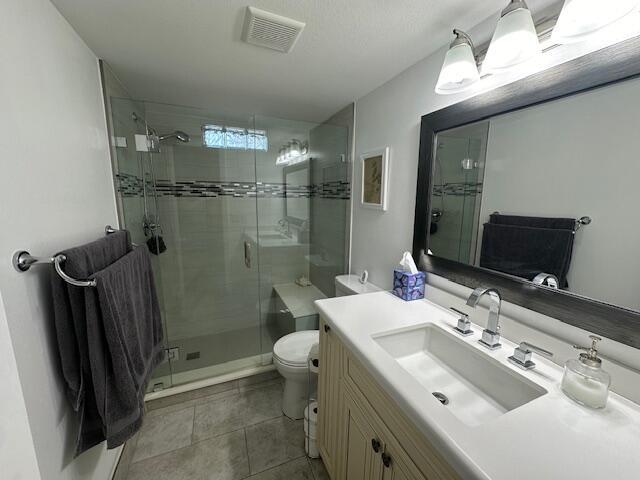 A bathroom features a glass-enclosed shower, a vanity with a white countertop, and gray towels — 2615 NE 3rd Court # 112, Boynton Beach FL 33435, BOYNTON BEACH, FL