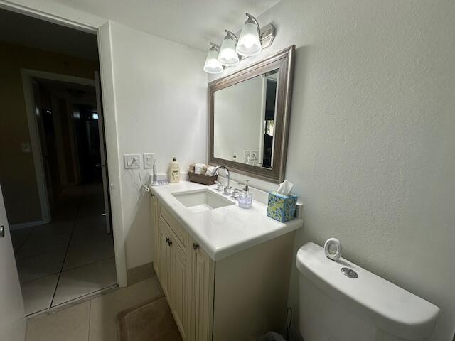 A bathroom features a white vanity with a sink, a mirror, and a toilet — 2615 NE 3rd Court # 112, Boynton Beach FL 33435, BOYNTON BEACH, FL