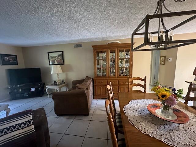 A dining area with a wooden table and hutch opens into a living room — 2615 NE 3rd Court # 112, Boynton Beach FL 33435, BOYNTON BEACH, FL