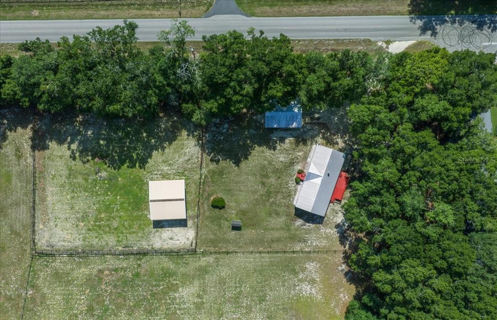 An aerial view shows a rural property with a house, outbuildings, and fenced pastures — 3551 NE 120TH STREET, ANTHONY, FL