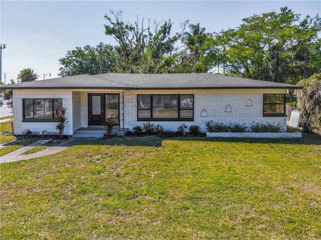 A single-story white brick house with a dark roof and black window frames — 1501 W FAIRBANKS AVENUE, WINTER PARK, FL