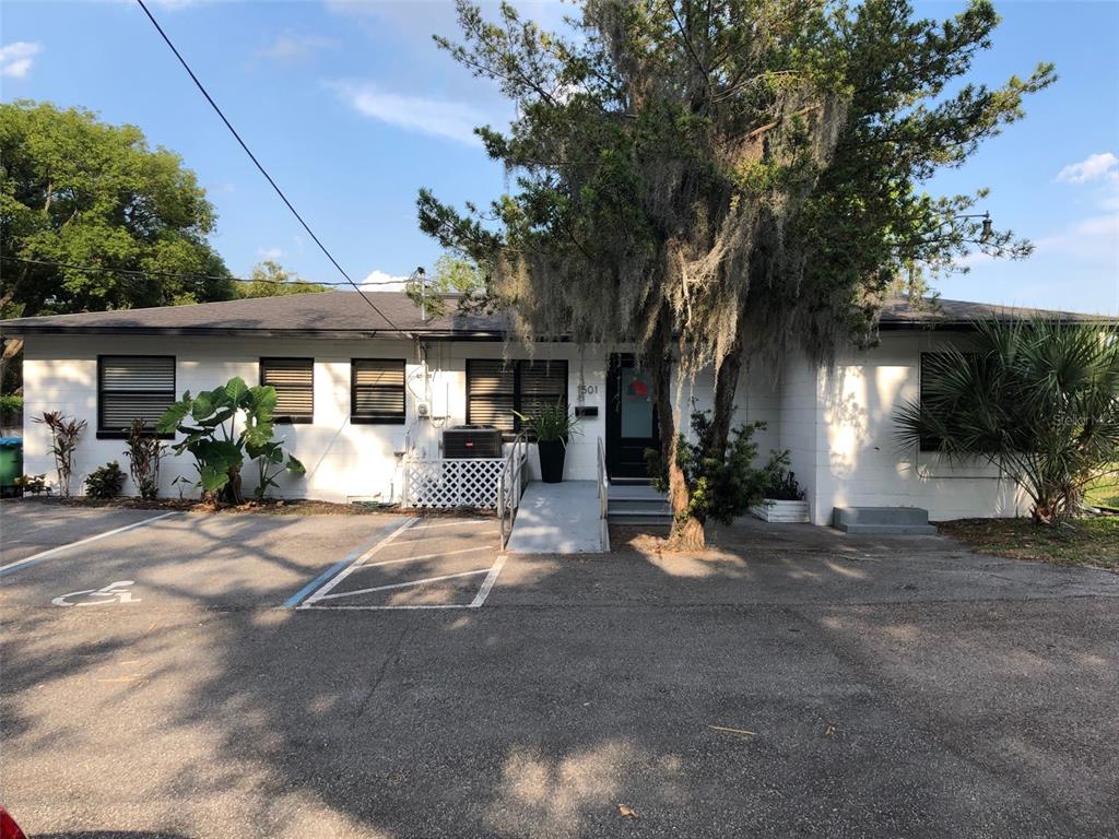 A single-story white building with a parking lot, handicap ramp, and large tree in front — 1501 W FAIRBANKS AVENUE, WINTER PARK, FL