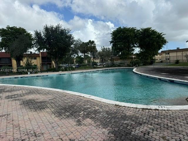 A large outdoor swimming pool is surrounded by a paved deck and residential buildings — 2854 NW 55th Ave # 2B, Lauderhill FL 33313, LAUDERHILL, FL