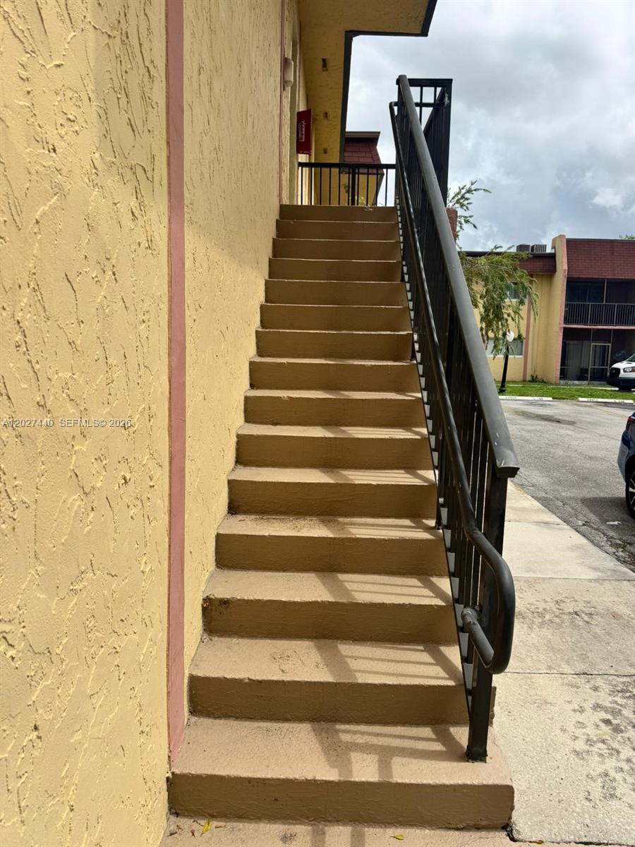 An exterior staircase with a black metal railing leads up to a building entrance — 2854 NW 55th Ave # 2B, Lauderhill FL 33313, LAUDERHILL, FL