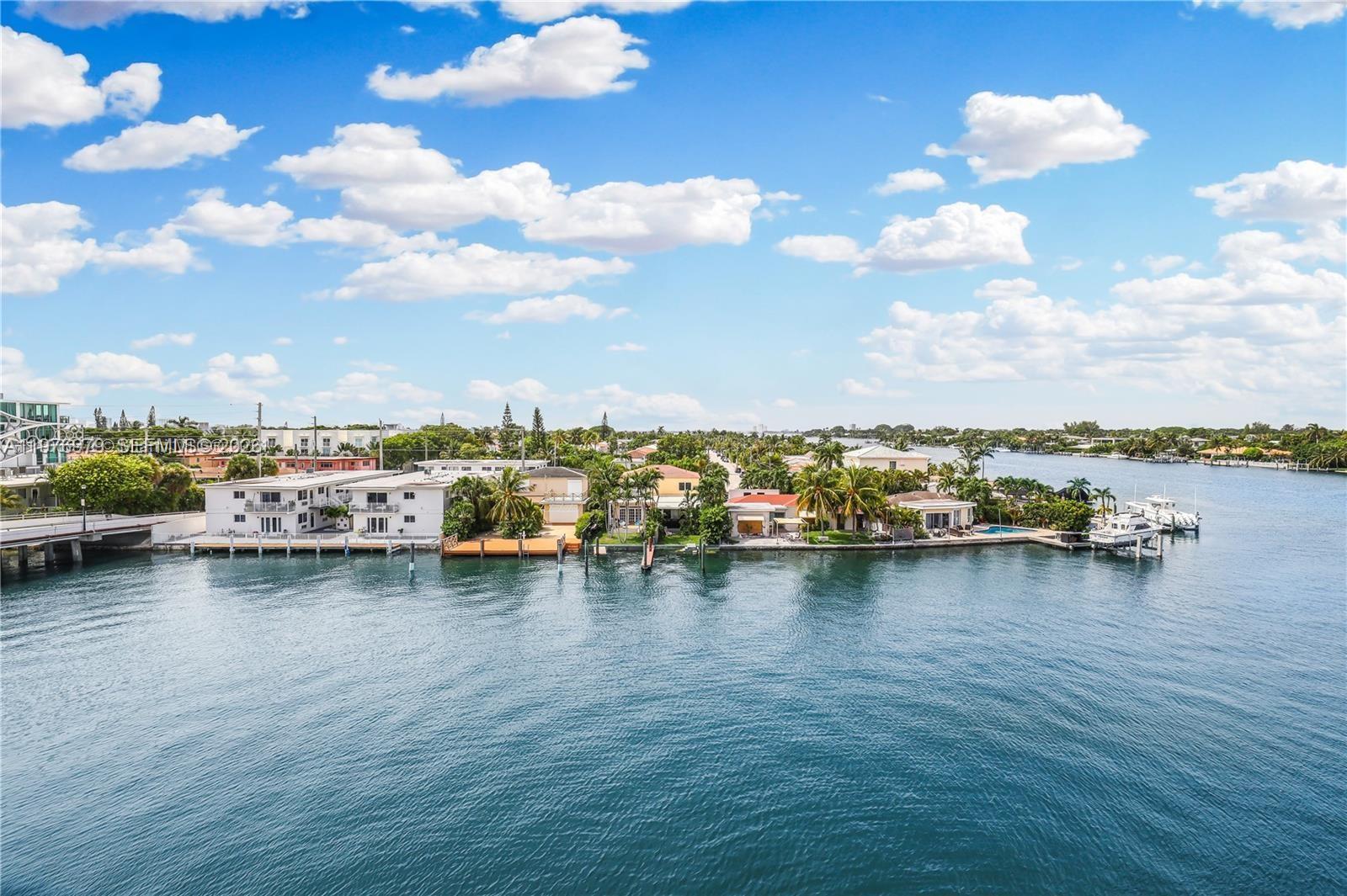 A view of a canal lined with residential buildings and boat docks under a cloudy sky — 8530 Byron Ave # 402, Miami Beach FL 33141, MIAMI BEACH, FL