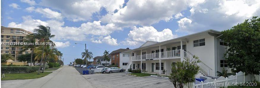 A two-story white apartment building sits beside a street with parked cars and palm trees — 3212 NE 10th St, Pompano Beach FL 33062, POMPANO BEACH, FL
