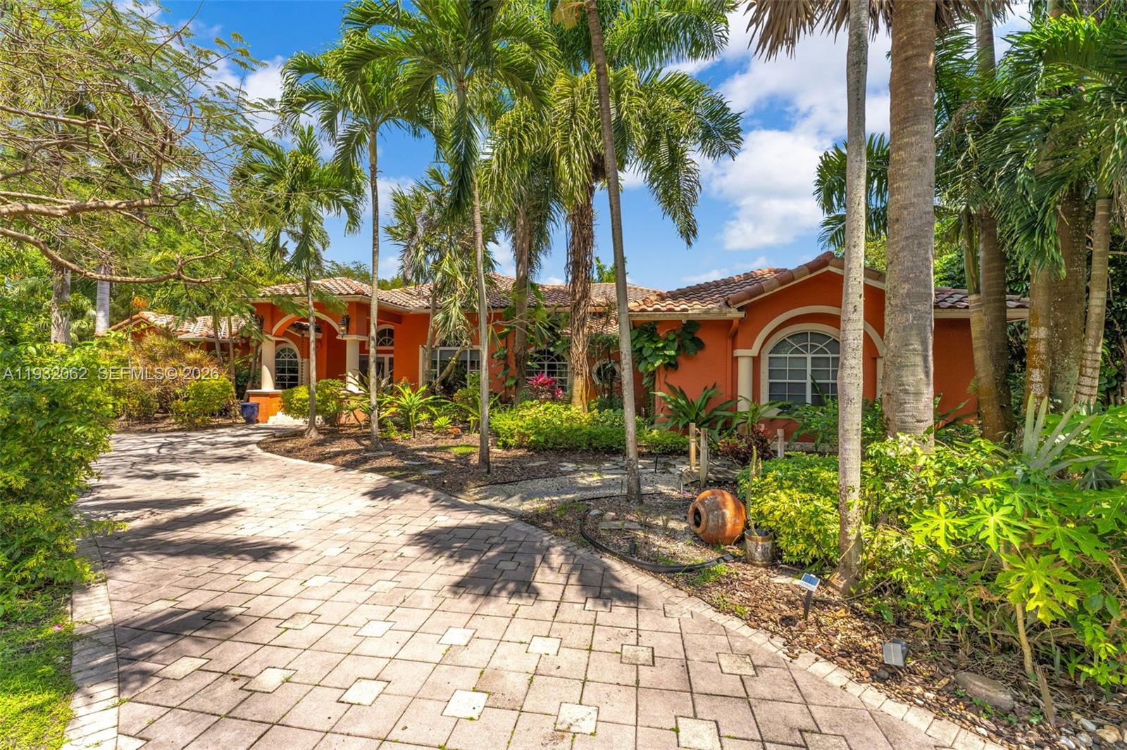 A single-story orange house with a tiled roof and a paved driveway surrounded by palms — 11825 S Mitchell Manor Cir, Pinecrest FL 33156, PINECREST, FL
