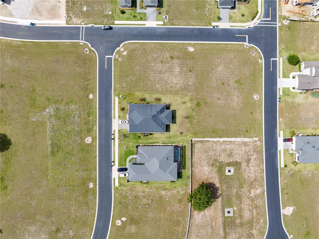 An aerial view shows two houses situated on a large, partially developed corner lot — 285 CALADIUM AVENUE, LAKE ALFRED, FL