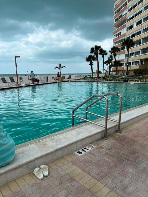 A swimming pool overlooks the ocean next to a multi-story building — 17920 GULF BOULEVARD UNIT 502, REDINGTON SHORES, FL