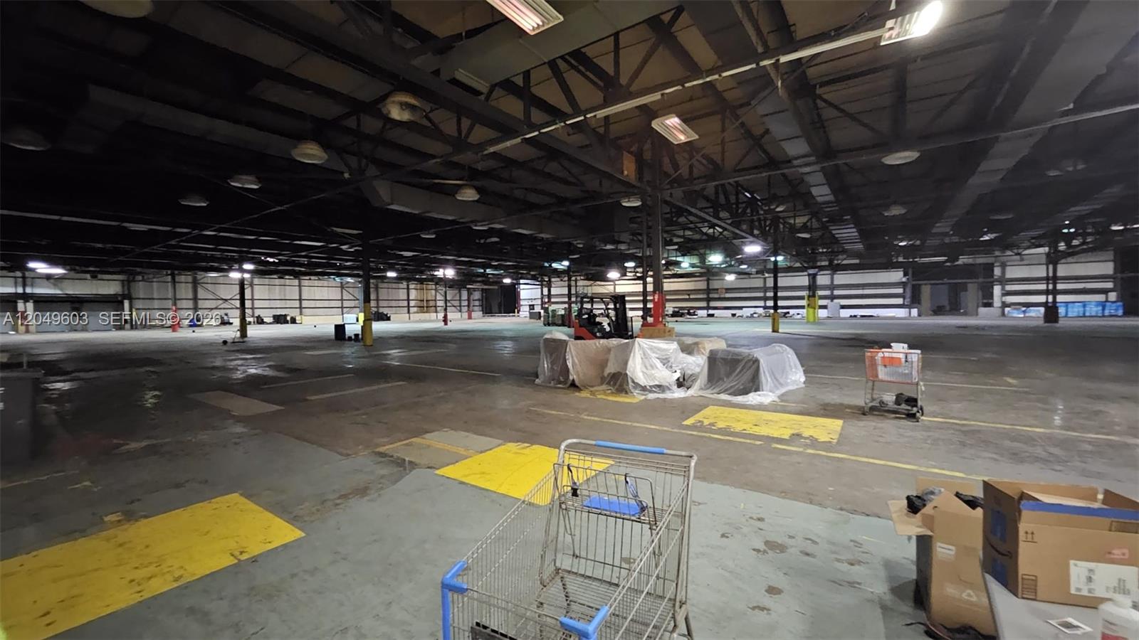 A large, open industrial warehouse space features concrete floors, exposed ceiling beams, and support columns — 2111 Old Shawnee Rd, OK 74403, OK