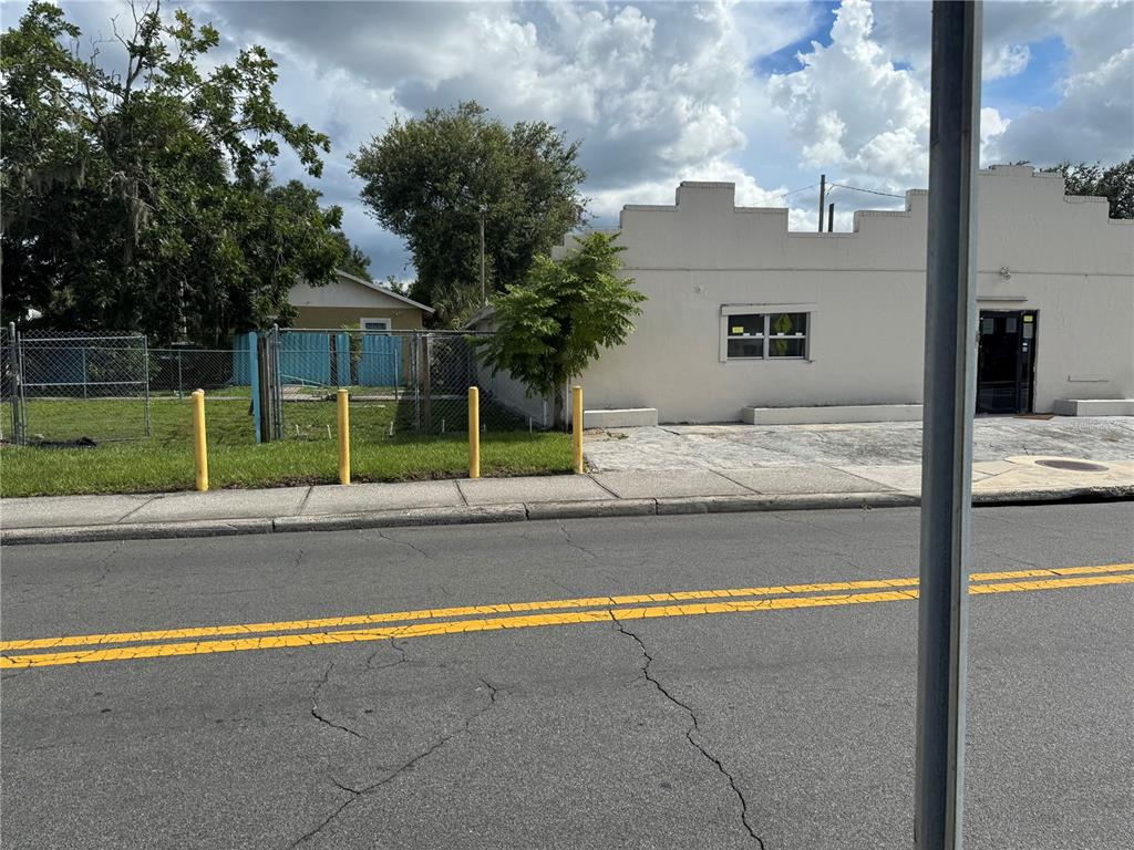 A single-story commercial building with a stepped parapet roof sits behind yellow bollards — 618 W 5TH STREET, LAKELAND, FL