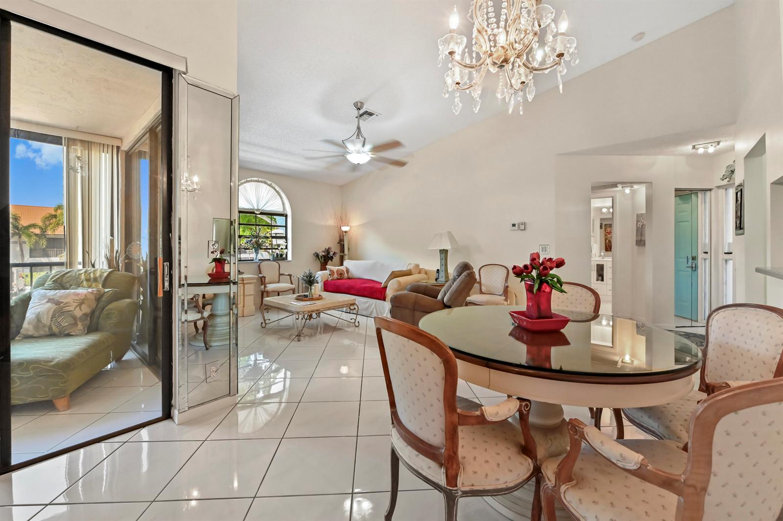 A bright living and dining area with white tile floors, a chandelier, and glass doors — 5450 Verona Drive # O, Boynton Beach FL 33437, BOYNTON BEACH, FL