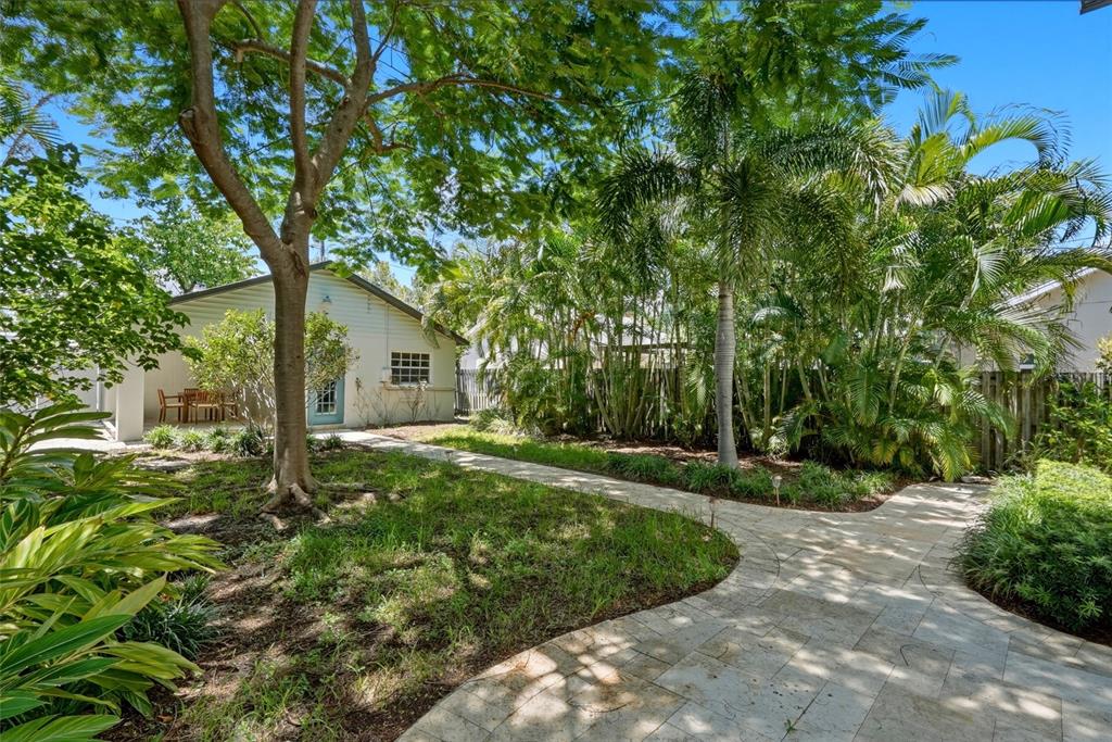 A modern kitchen features white cabinets, granite countertops, a large island with bar seating, and dark flooring — 2720 10TH STREET N, ST PETERSBURG, FL